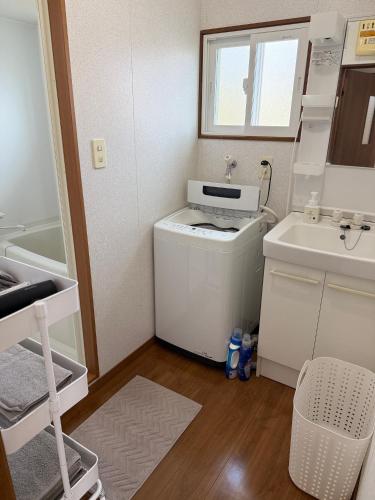 a small kitchen with a washing machine and a sink at 宿Oshikiri 04 in Shibushi