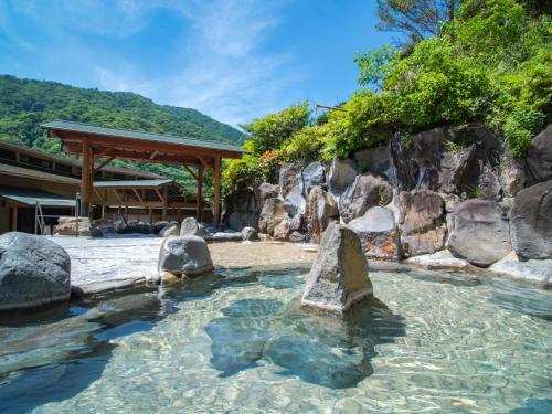 a pool of water with rocks in front of a building at Hakonenomori Okada in Hakone