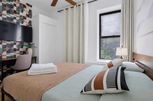 a bedroom with a bed and a desk and a window at 2 BD Tranquil Unit close to Central Park in New York