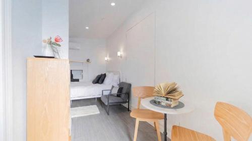 a small room with a bed and a table and chairs at Nouvelle Studio in Epsom