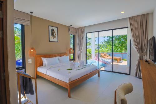 a bedroom with a bed and a balcony at FarmSaijai Kohphangan in Hinkong