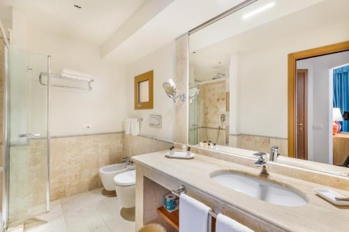 a bathroom with a sink and a toilet at Hotel Marana in Golfo Aranci