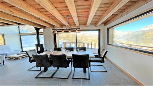 a dining room with a table and chairs and windows at Chalet - Superbe Chalet 12 pers MAE-2644 in Les Prés