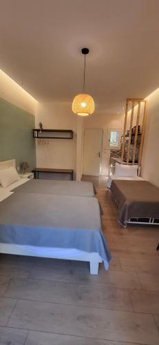 a bedroom with a large white bed and a chandelier at Amelia's Garden ΙΙ in Kavos
