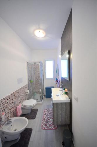 a bathroom with two sinks and a toilet and a tub at Villa Giorgia in Cefalù
