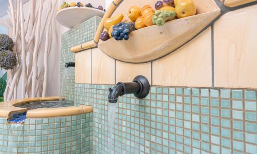 a bathroom with a bowl of fruit on a toilet at Hotel Wechselberger by Alpeffect Hotels in Saalbach-Hinterglemm