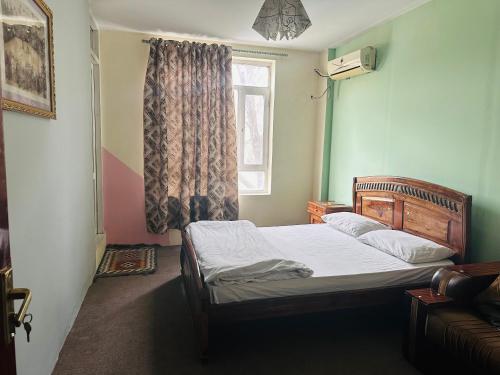 a small bedroom with a bed with a window at Afghania Guest House in Kabul