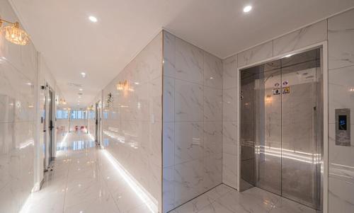 a bathroom with a walk in shower and a glass door at Daejeon Comma Hotel in Daejeon