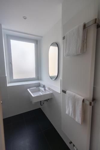 a bathroom with a sink and a window at Palazzo Hotel in Mannheim