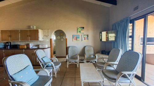 a room with chairs and a table and a kitchen at Allesreg Chalet B2 in Margate