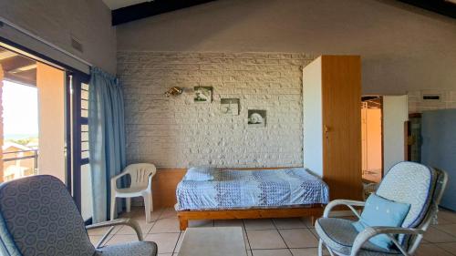 a bedroom with a bed and chairs in a room at Allesreg Chalet B2 in Margate