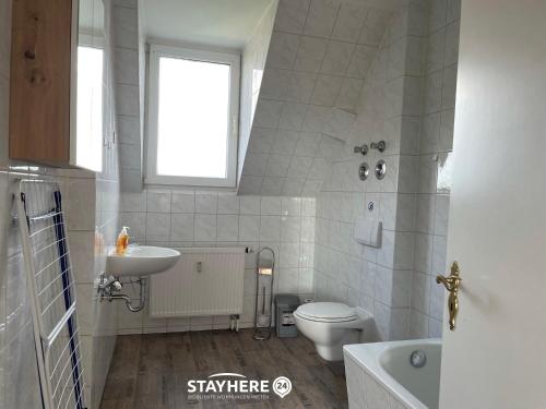 a bathroom with a sink toilet and a window at StayHere24 Maisonette-Wohnung mit großem Garten in Leipzig
