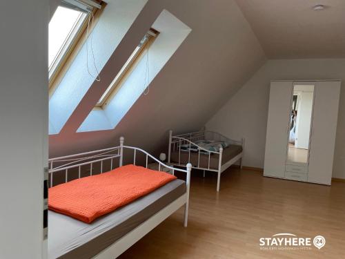 a bedroom with two bunk beds in a attic at StayHere24 Maisonette-Wohnung mit großem Garten in Leipzig