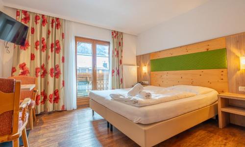 a bedroom with a large bed in a room at Hotel Wechselberger by Alpeffect Hotels in Saalbach-Hinterglemm