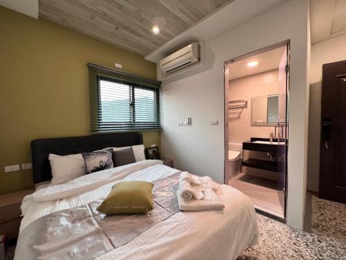 a bedroom with a large bed and a bathroom at Aren Inn in Zhushan