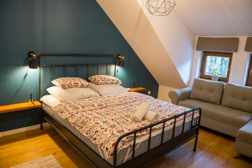 a bedroom with a bed and a couch and a chair at Apartamenty Centrum Biskupiec in Biskupiec