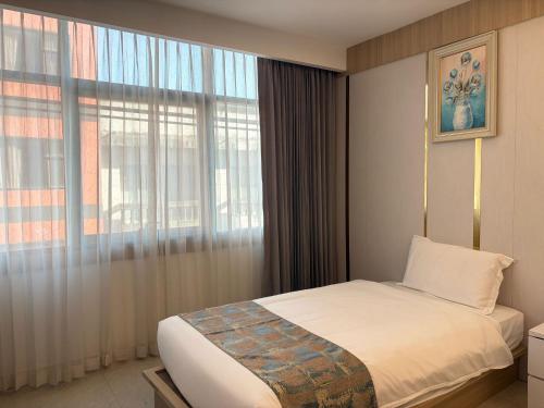 a bedroom with a bed and a large window at Palette Luxe Jomtien Beach Pattaya in Jomtien Beach