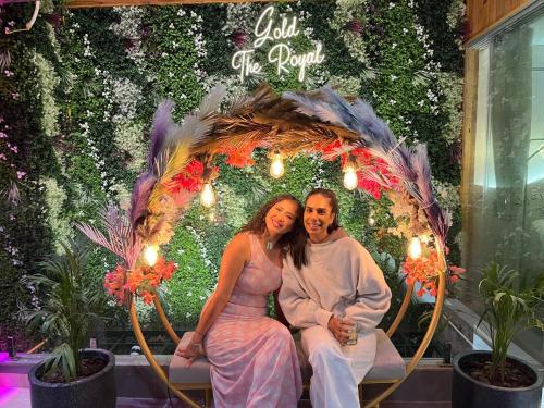 a man and a woman sitting on a bench in an umbrella at Hotel Gold The Royal A Luxurious Stay- Near New Delhi Railway Station & Connaught Place in New Delhi