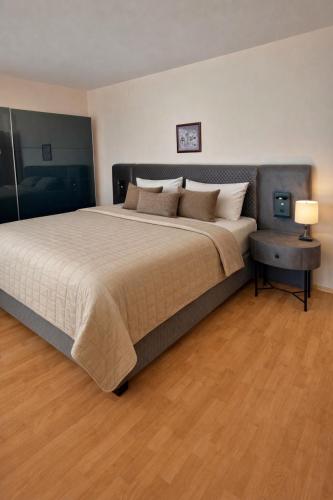 a bedroom with a large bed and a wooden floor at Sveti Vlas Fort Noks Panorama SAS in Sveti Vlas
