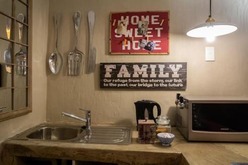 a kitchen counter with a sink and utensils on the wall at Red olive guesthouse in Parys