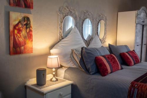 a bedroom with a bed and two mirrors on the wall at Red olive guesthouse in Parys