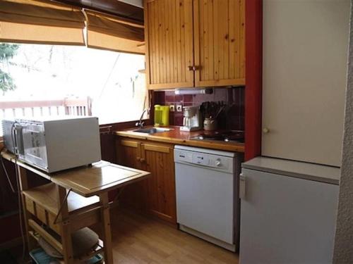 a kitchen with wooden cabinets and a white refrigerator at Résidence Lienz - Studio cabine avec terrasse exposï¿½e Sud MAE-8324 in Barèges