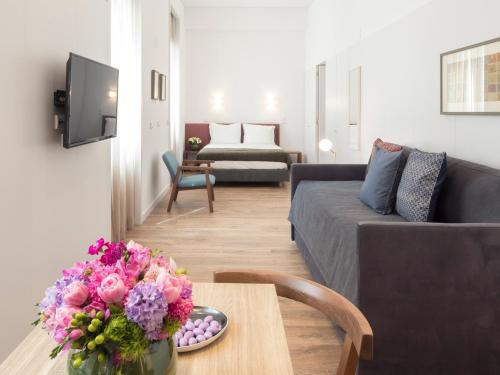 a living room with a couch and a table with flowers at LSA Chiado Emenda by Numa in Lisbon
