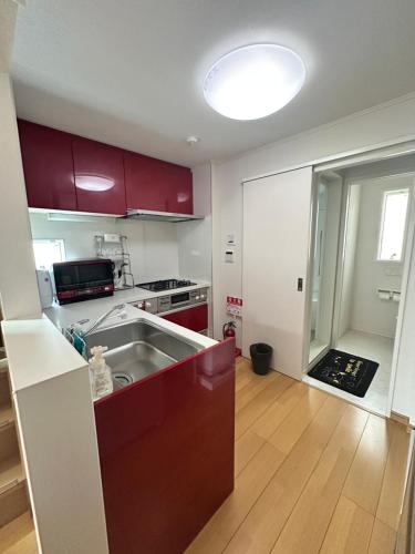 a kitchen with red cabinets and a kitchen sink at Ueno 10minutes, Tokyo University 10minutes, three BR, three toilets, Max 10 people Free parking in Tokyo