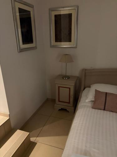 a bedroom with a bed and a lamp on a night stand at Confort Taillans in Donzère