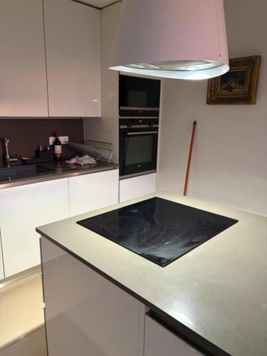 a kitchen with white cabinets and a black counter top at Confort Taillans in Donzère