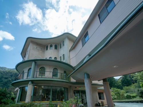 a large white house with a green trim at Hakonenomori Okada in Hakone