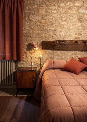 a bedroom with a bed and a brick wall at Casa Vecchia in Colsantangelo