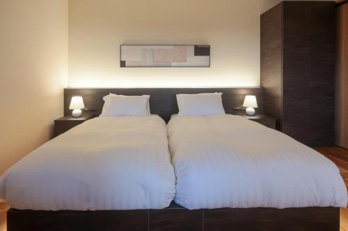 two beds sitting next to each other in a bedroom at Wellリゾート富士 in Gotemba