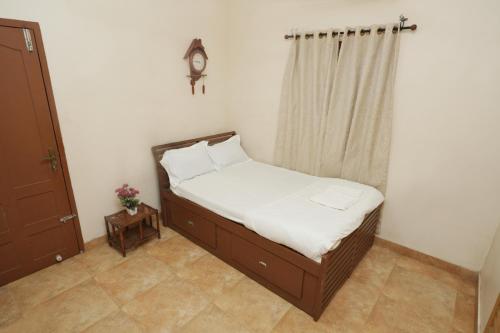 a small bedroom with a bed and a window at Spicened inn in Cochin