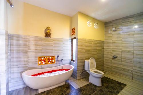 a bathroom with a large tub and a toilet at Asri Sari Villa Ubud in Ubud