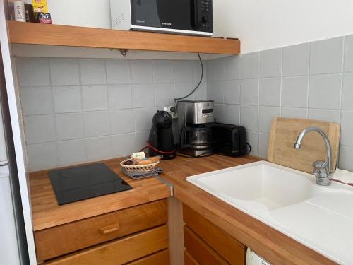 un bancone da cucina con un lavandino e una macchina per il caffè di Tropical Cocooning a Saint-François