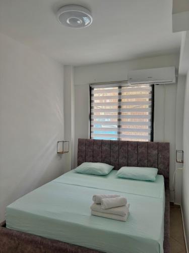 a bedroom with a bed with two towels on it at SeaStep Apartment Golem in Golem