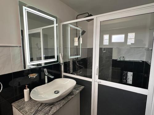 a bathroom with a white sink and a shower at The Woodside Manor in Nuwara Eliya