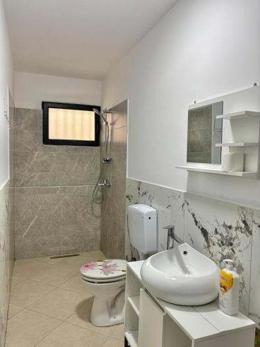 a bathroom with a white toilet and a sink at SeaStep Apartment Golem in Golem