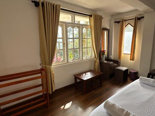 a bedroom with a bed and a large window at The Woodside Manor in Nuwara Eliya