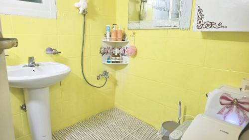 a yellow bathroom with a sink and a toilet at 핑크하우스옥상바베큐파티 in Daejeon