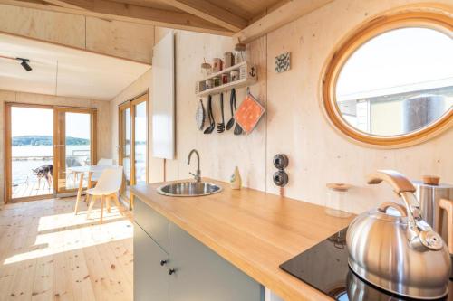 a kitchen with a counter with a sink and a table at Hausboot Alma in Schleswig