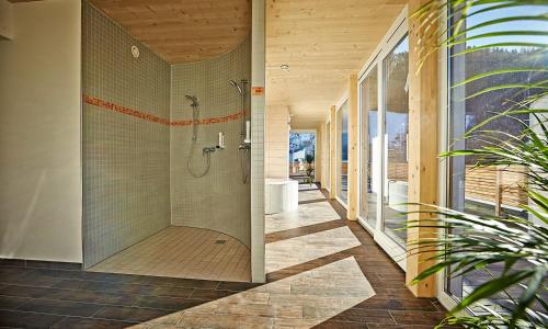 a bathroom with a shower and a tub at Hotel Planai by Alpeffect Hotels in Schladming