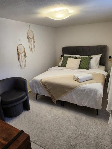 a bedroom with a large bed and a chair at Studio Nessa with a private jacuzzi in Krk