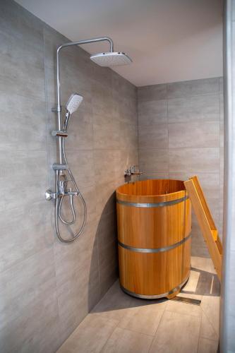 a bathroom with a wooden tub and a shower at Hotel zur Isar in Plattling