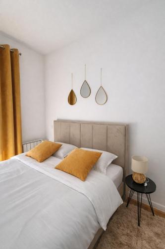 a bedroom with a large white bed with two pillows at Ilma Apartmani Musique in Tuzla