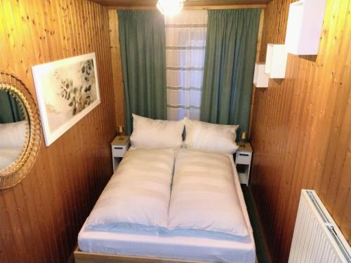 a small bed in a room with a window at Ferienhaus Waldkrone in Arrach