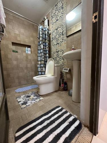 a bathroom with a toilet and a sink at Koenigs Lodging House in Bocaue