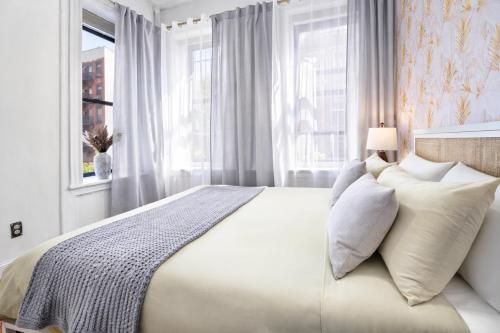 a bedroom with a large bed with white pillows at Classy 2BD Home in Manhattan in New York