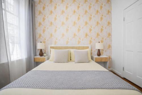 a bedroom with a white bed with two lamps at Classy 2BD Home in Manhattan in New York